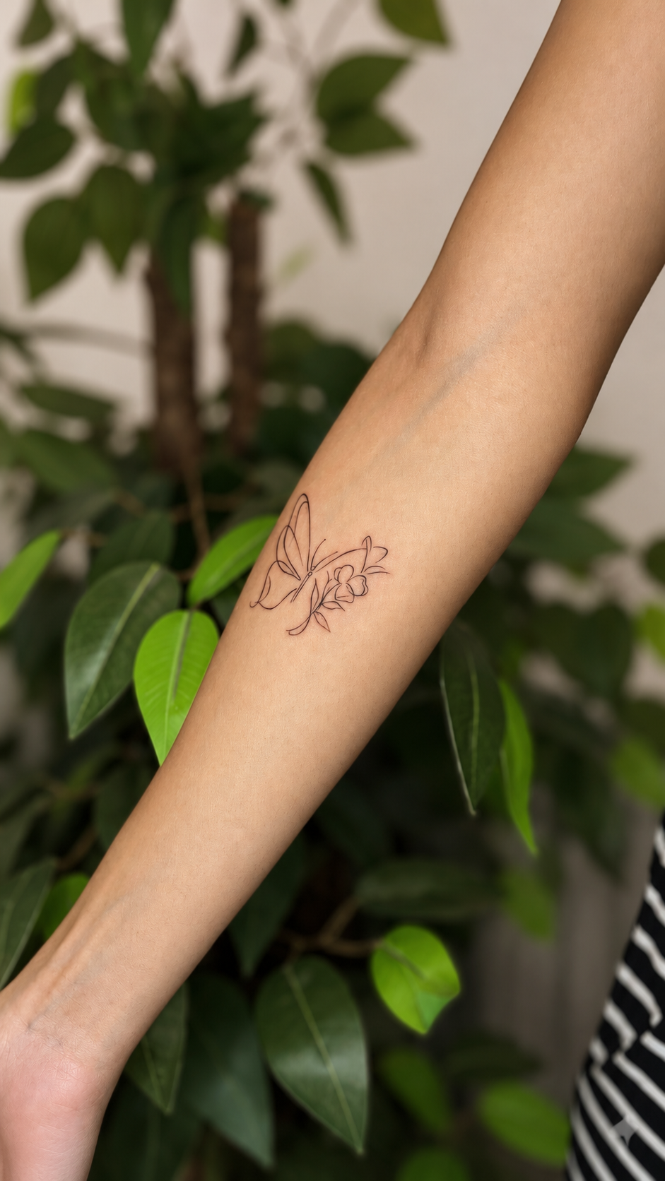 Tatuaje botánico de línea fina en el antebrazo